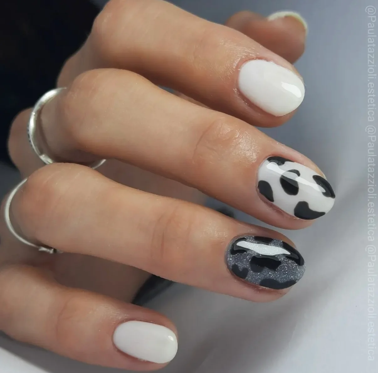 Capping clásico en blanco con dos uñas con diseño de manchas negras